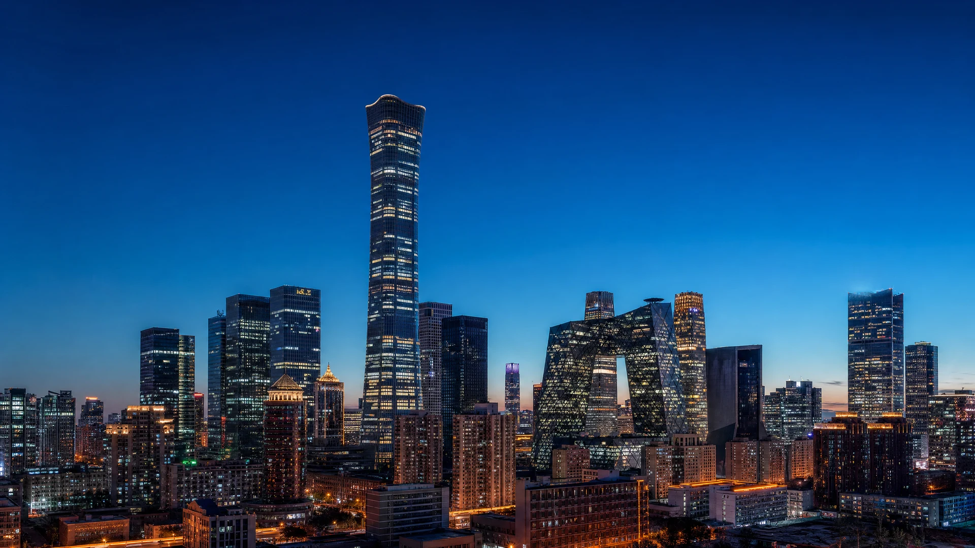 Modern urban skyline at dusk with deep blue gradient sky and glowing office tower windows